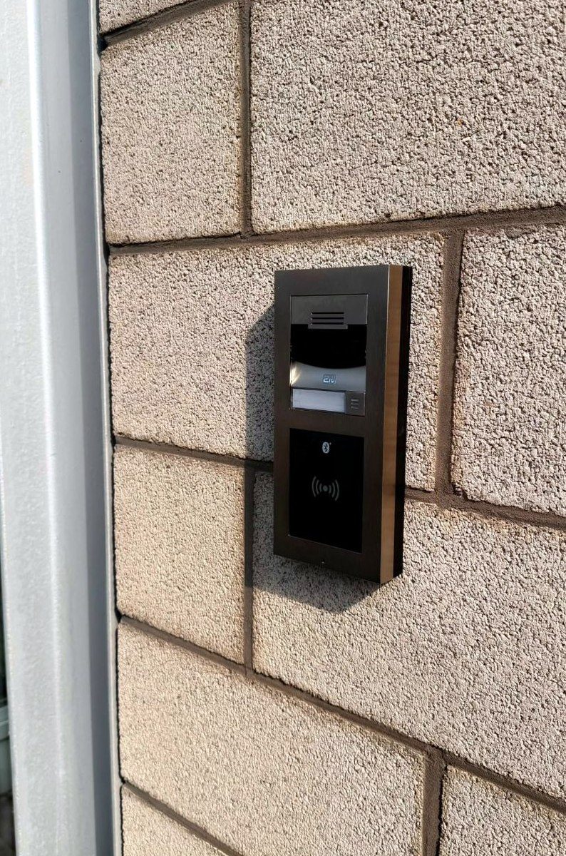 Un interphone vidéo à lecteur de badge installé à l’entrée d’un bâtiment.